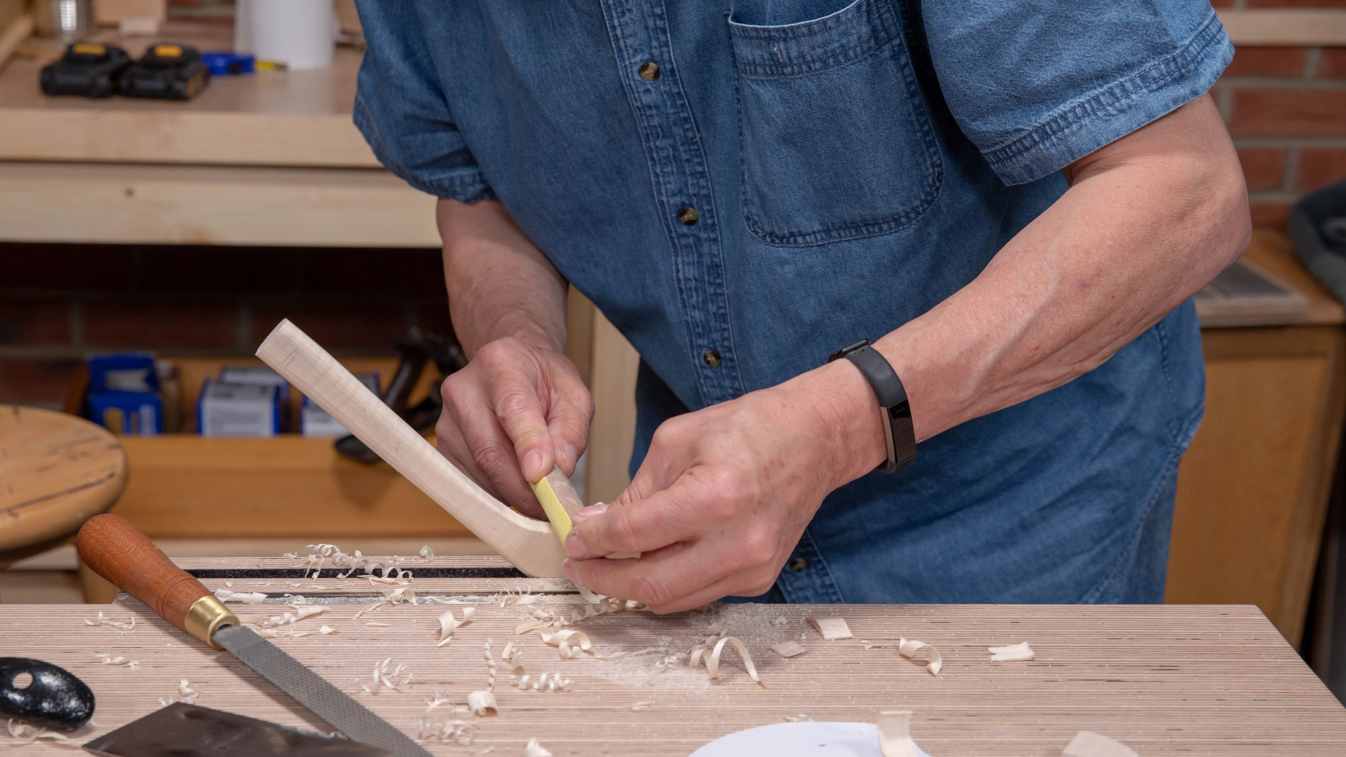 Wrapping sandpaper around a dowel works like a round file for the tight internal curve