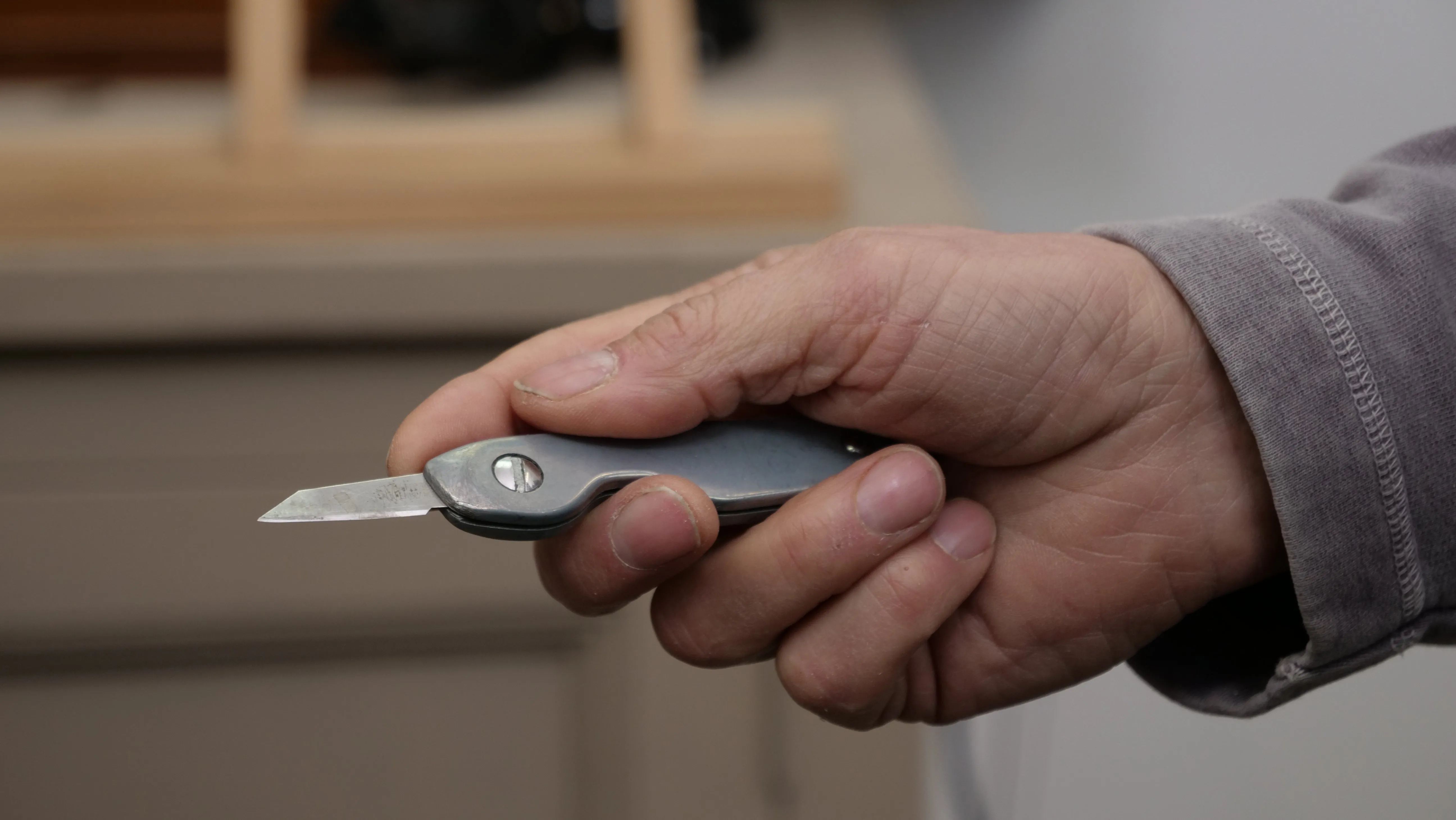 Use your dominant hand to grip around the handle using your thumb and index finger to point forward