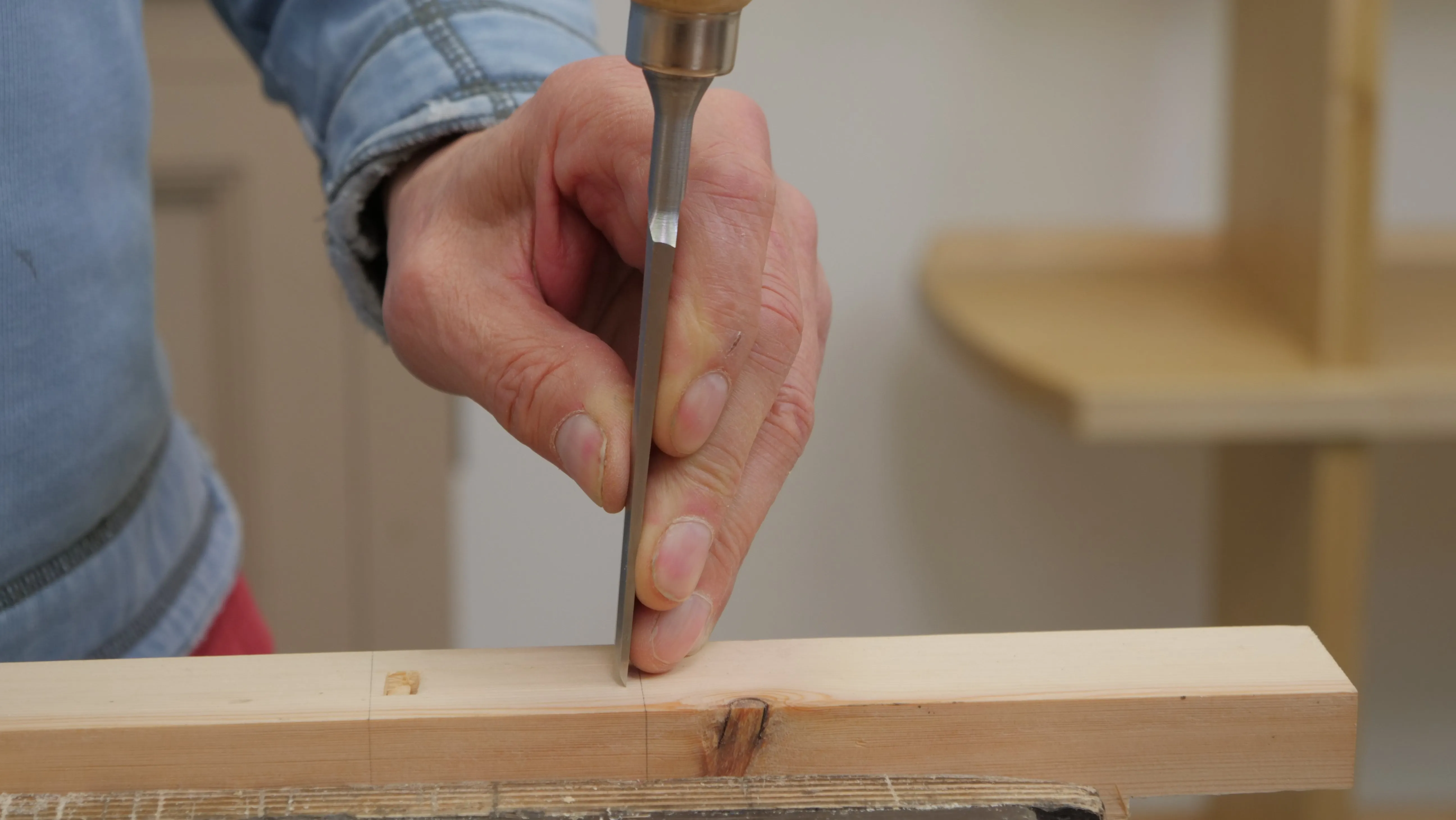 Using the fingers and thumb to support the blade of the chisel near to the cutting edge, with the fingers tracing the surface of the wood, gives more accuracy to start the chisel. We often change hand positions, once the chisel has cut through the surface, to use the handle.