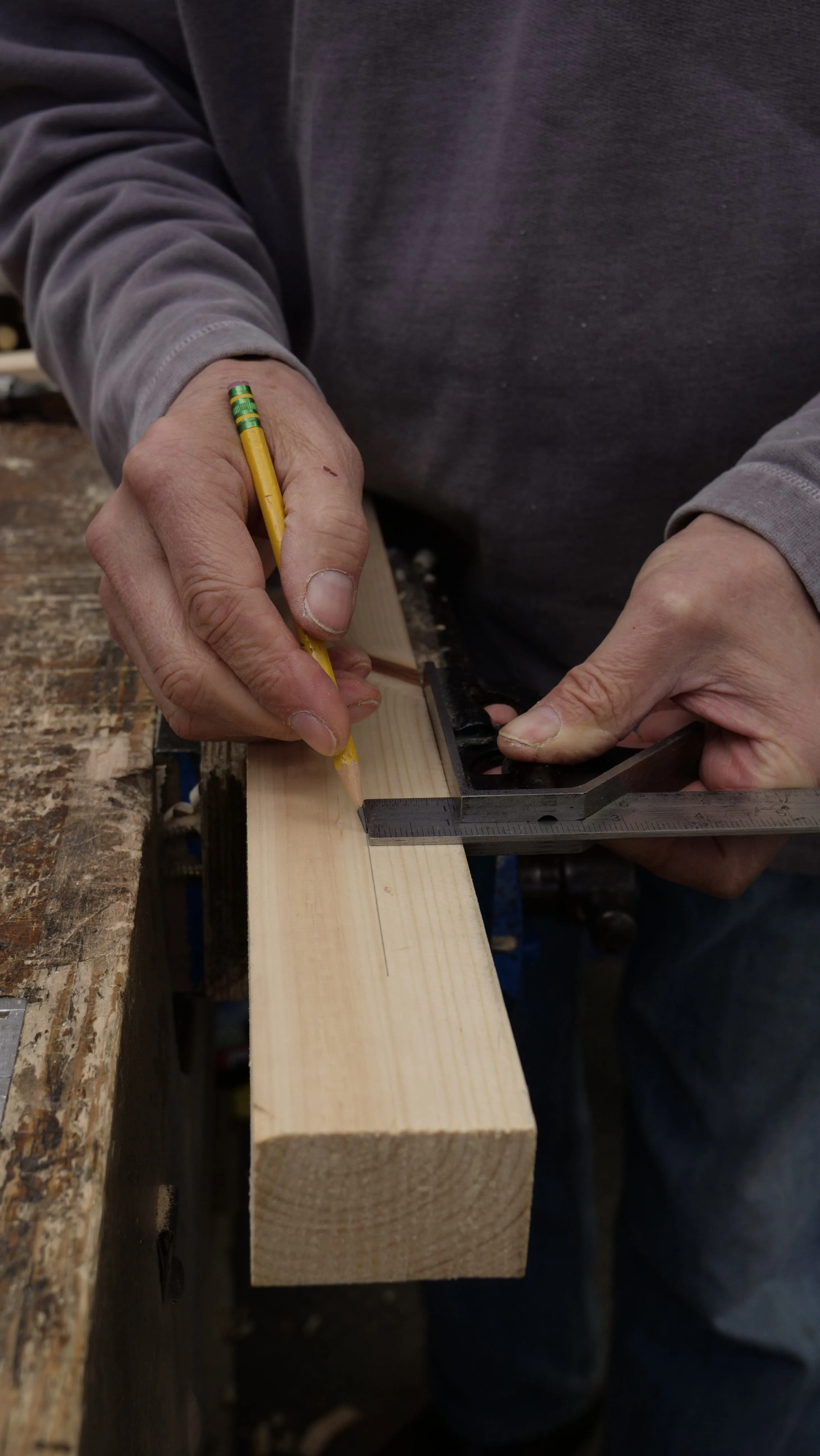 You can use the head as a fence to guide the pencil parallel to the edge down the length of the wood