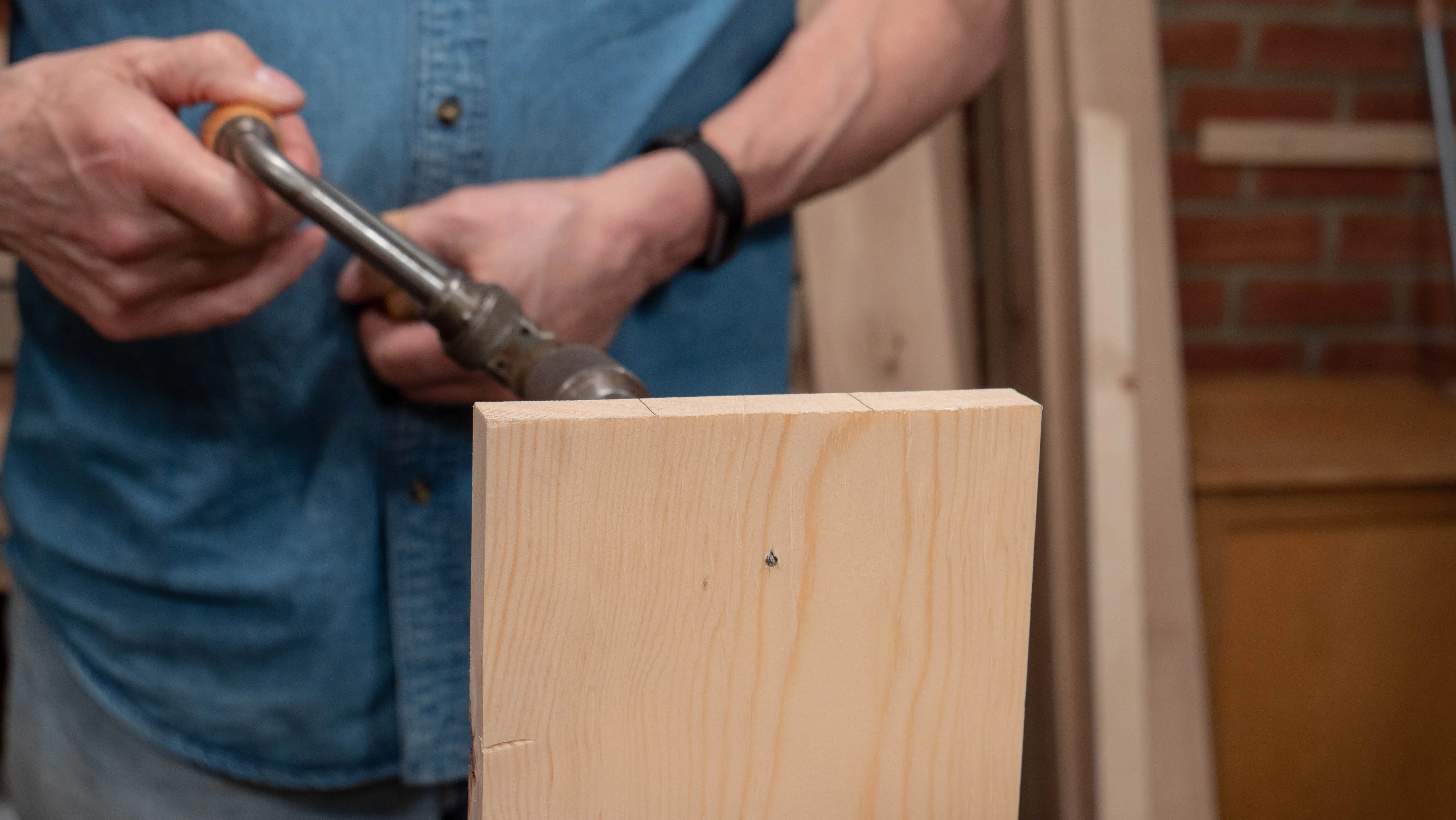 Stop when you see (or feel with your fingertips) the point of the auger protruding to the other side