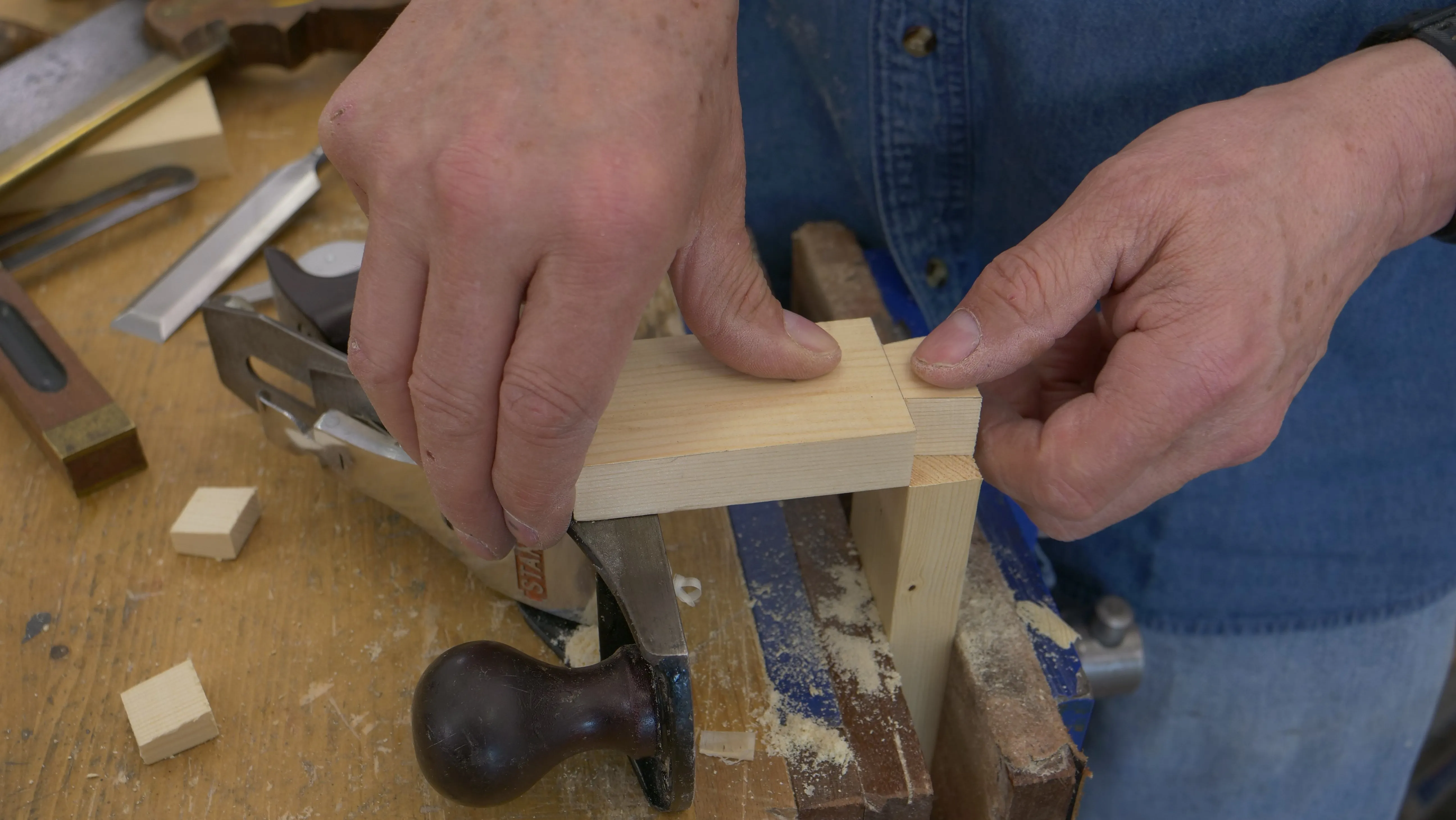 Using your plane as a platform, place the tail of the tail piece directly over the pin piece. Align the shoulders with the inside of the pin piece